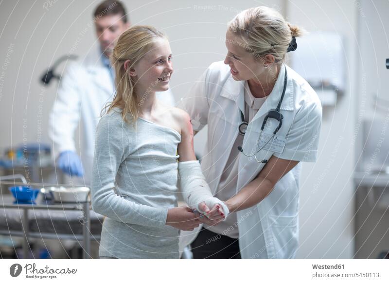 Arzt spricht mit verletztem Mädchen im Krankenhaus Doktoren Ärzte Patientin Patientinnen Gipsverband Gipsverbände Unfall Klinik Kliniken Krankenhäuser