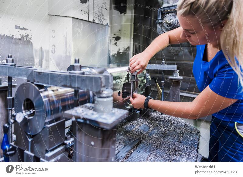 Frau arbeitet an einer Maschine in einer Industriefabrik weiblich Frauen Fabrik Fabriken arbeiten Arbeit Maschinen Erwachsener erwachsen Mensch Menschen Leute