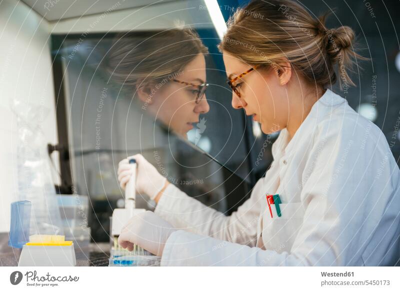Labortechniker beim Pipettieren im Labor Labore Frau weiblich Frauen untersuchen prüfen arbeiten Arbeit Laborantin Laborantinnen Arbeitsplatz Arbeitsstätte