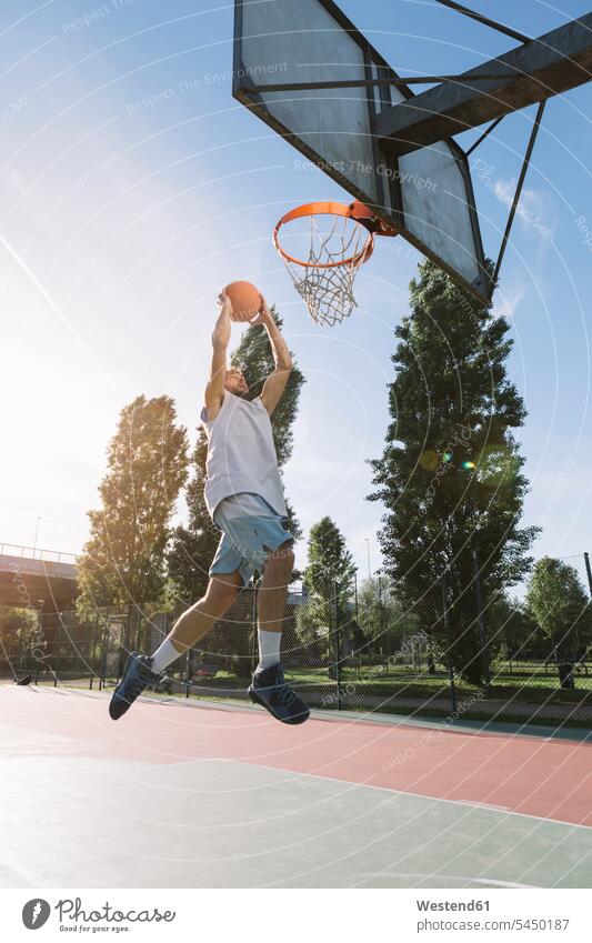 Mann spielt Basketball Basketbaelle Basketbälle springen hüpfen Freizeit Muße Sport Männer männlich Basketballspieler Basketballer werfen Wurf Sprung Spruenge