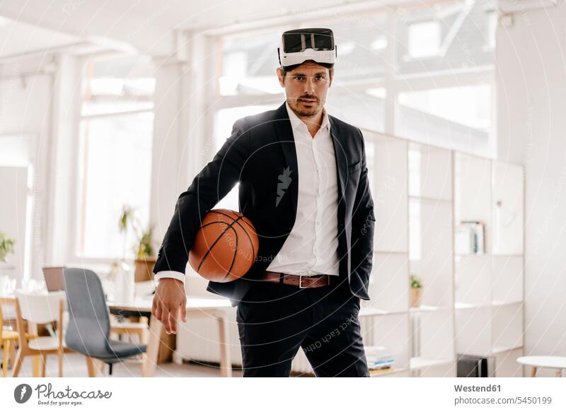 Geschäftsmann mit VR-Brille hält Basketball im Amt Mann Männer männlich 3D Brille 3D-Brille Businessmann Businessmänner Geschäftsmänner Erwachsener erwachsen
