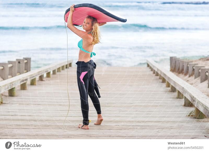 Frau geht mit Surfbrett zum Strand Surfbretter surfboard surfboards Surfen Surfing Wellenreiten Beach Straende Strände Beaches gehen gehend tragen