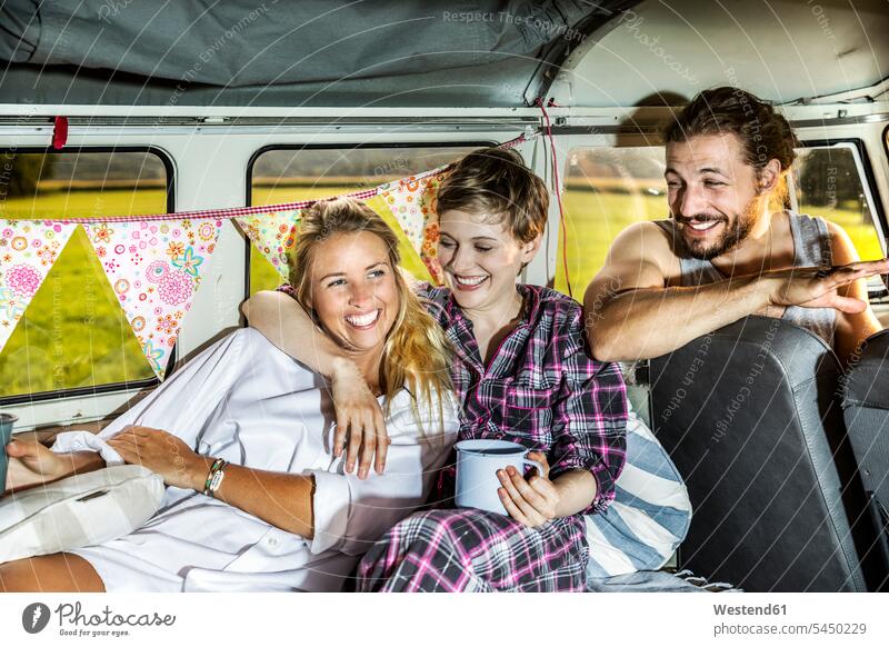 Glückliche Freunde in einem Kleinbus beim Kaffeetrinken Kleinbusse Spaß Spass Späße spassig Spässe spaßig lachen Kraftfahrzeug Verkehrsmittel KFZ Verkehrswesen