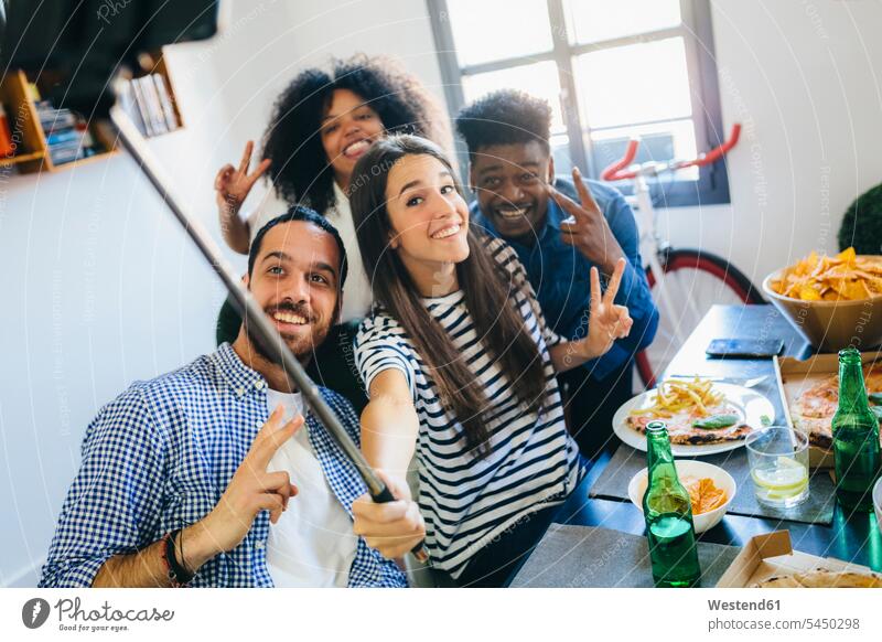 Gruppe von Freunden posiert für ein Selfie am Esstisch zu Hause Tisch Tische Selfies Spaß Spass Späße spassig Spässe spaßig Handy Mobiltelefon Handies Handys