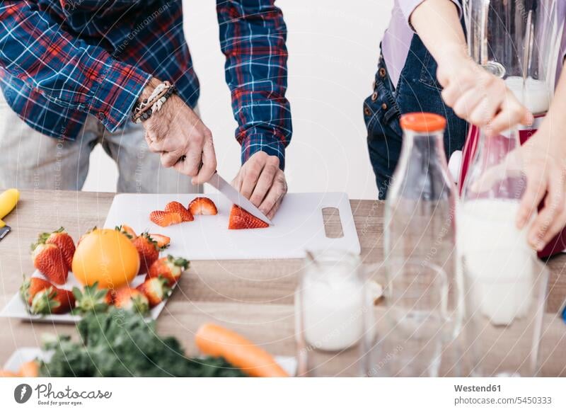 Ehepaar beim Zubereiten von Smoothies mit frischem Obst und Gemüse, Teilansicht Paar Pärchen Paare Partnerschaft zubereiten kochen Essen zubereiten Mensch