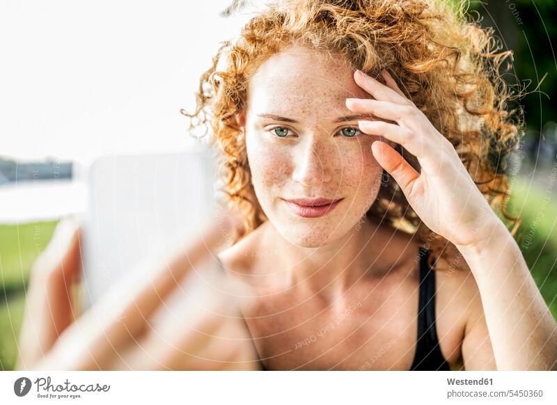 Porträt einer sommersprossigen jungen Frau, die ein Selfie mit ihrem Mobiltelefon macht Portrait Porträts Portraits Sommersprossen weiblich Frauen Selfies