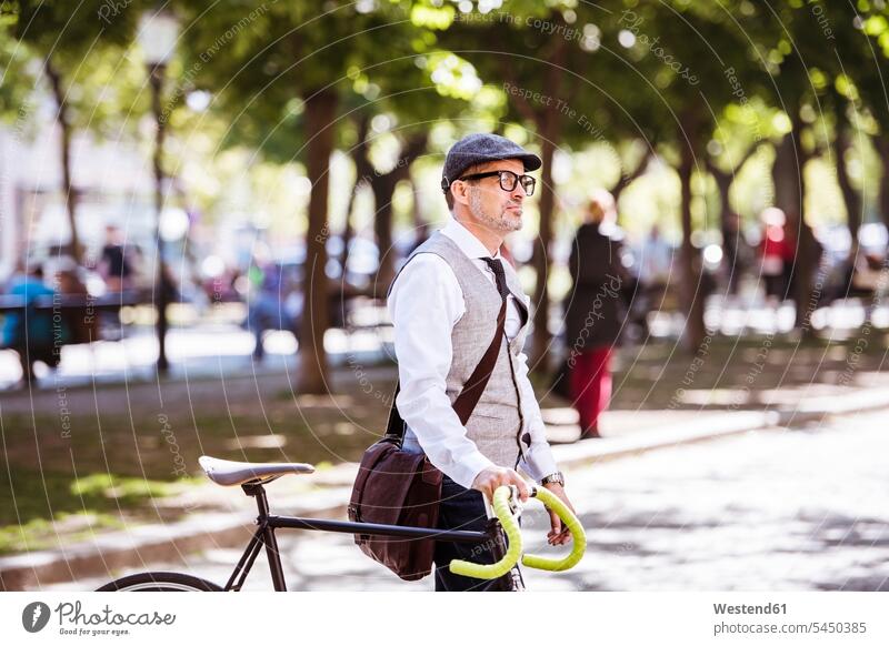 Reifer Geschäftsmann auf dem Fahrrad in der Stadt Bikes Fahrräder Räder Rad Mann Männer männlich staedtisch städtisch Raeder Erwachsener erwachsen Mensch