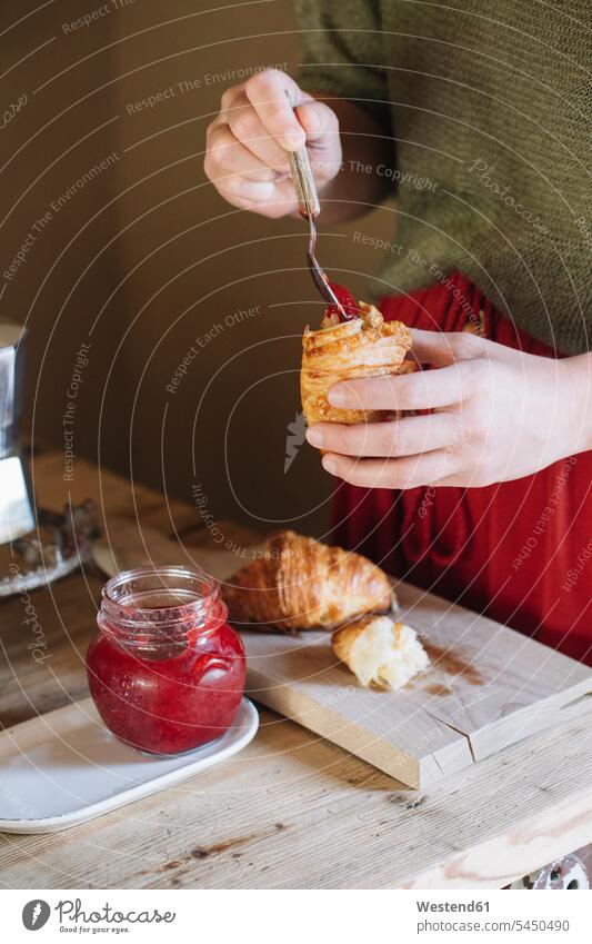 Nahaufnahme einer Frau, die hausgemachte Croissants mit Marmelade probiert weiblich Frauen essen essend Hoernchen Cornetto Cornettos Hörnchen Erwachsener