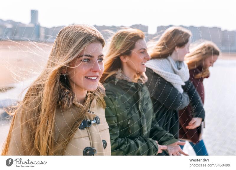 Vier Freunde beim Spaziergang am Strand Freundinnen Freundschaft Kameradschaft spazierengehen Spaziergang machen spazieren gehen Teenagerin junges Mädchen