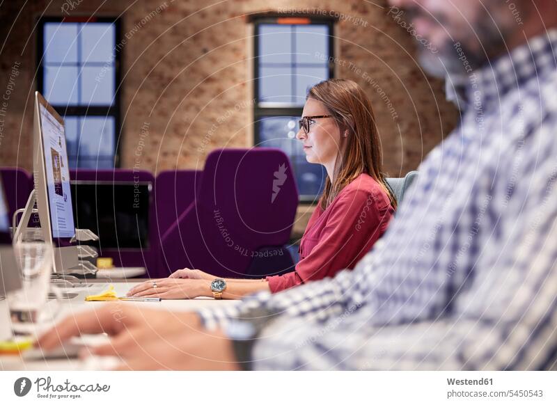 Frau arbeitet schwerpunktmäßig am PC Kollegin Kolleginnen Geschäftsleute Geschäftspersonen sitzen sitzend sitzt arbeiten Arbeit Büro Office Büros Kollegen