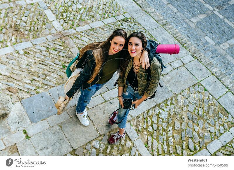 Zwei reisende junge Frauen stehen auf einem Schleppplatz lächeln Freundinnen Freunde Freundschaft Kameradschaft umarmen Umarmung Umarmungen Arm umlegen Kameras