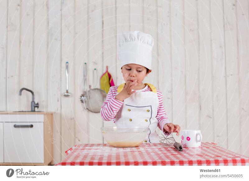 Kleines Mädchen, das Waffeln zubereitet und eine Kochmütze trägt backen Teig stehen stehend steht Küche weiblich Essen Food Food and Drink Lebensmittel