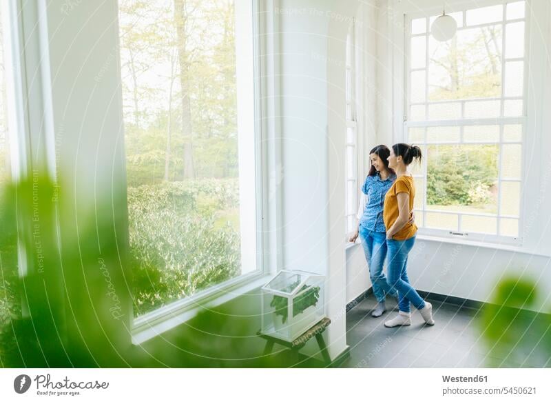 Zwei Frauen mit Kräutern in Glaskasten am Fenster weiblich stehen stehend steht Erwachsener erwachsen Mensch Menschen Leute People Personen Zuhause zu Hause