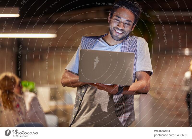 Junger Mann arbeitet in einem kreativen Start-up-Unternehmen und benutzt einen Laptop arbeiten Arbeit junger Mann junge Männer Kreative Kreativer