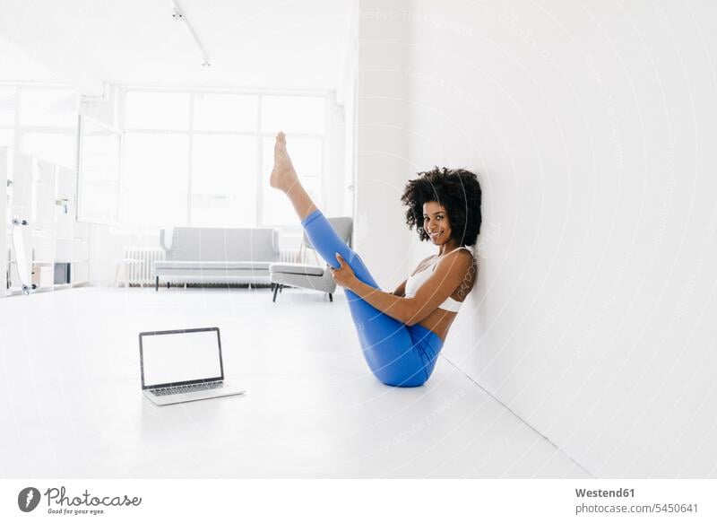 Junge Frau praktiziert Yoga mit Laptop an ihrer Seite fit Online üben ausüben Übung trainieren lernen Notebook Laptops Notebooks Training weiblich Frauen