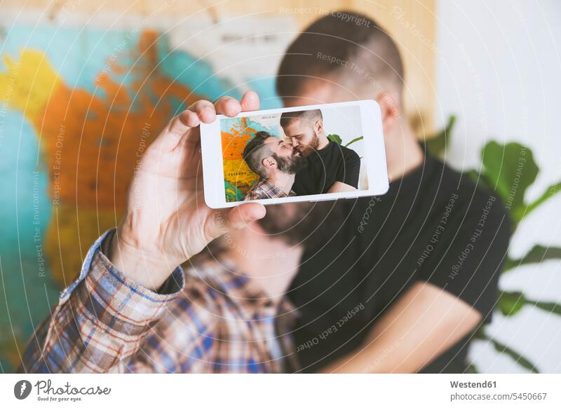 Junges schwules Paar macht ein Selfie mit Smartphone, Nahaufnahme Pärchen Paare Partnerschaft Homosexueller Mann Homosexuelle Maenner Schwuler