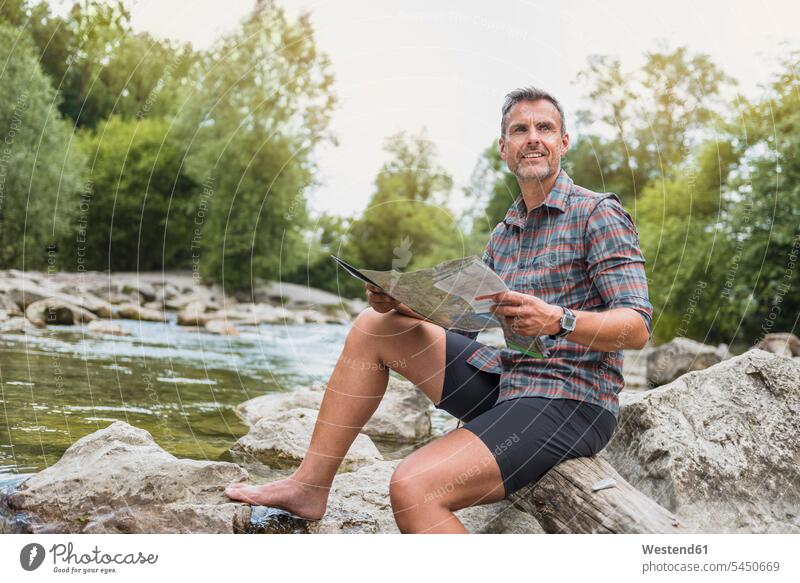 Wanderer am Flussufer sitzend mit Karte Karten wandern Wanderung Mann Männer männlich Fluesse Fluß Flüsse Pause Erwachsener erwachsen Mensch Menschen Leute