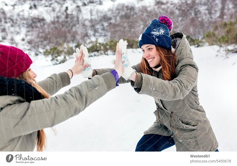 Zwei beste Freunde spielen Kämpfe im Schnee Freundinnen lächeln Winter winterlich Winterzeit Spaß Spass Späße spassig Spässe spaßig Freundschaft Kameradschaft