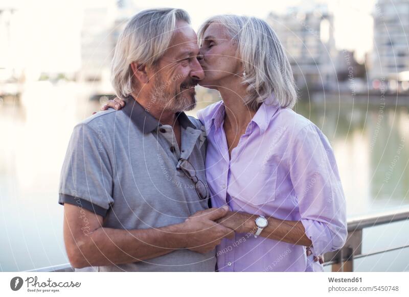 Älteres Ehepaar macht eine Städtereise, küsst und umarmt sich unterwegs auf Achse in Bewegung glücklich Glück glücklich sein glücklichsein Paar Pärchen Paare