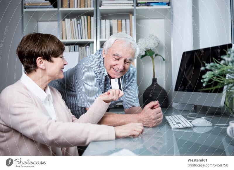 Älteres Ehepaar kauft online mit Kreditkarte ein Europäer Kaukasier Europäisch kaukasisch Paar Pärchen Paare Partnerschaft Online-Shopping Online Shopping
