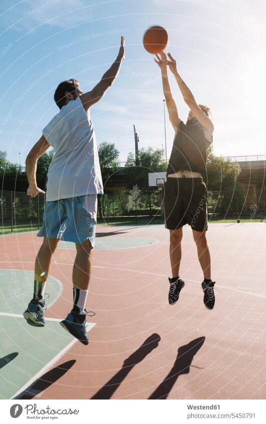 Basketball spielende Männer Freizeit Muße Sport Mann männlich springen hüpfen Basketballspieler Basketballer werfen Wurf Basketbaelle Basketbälle Erwachsener