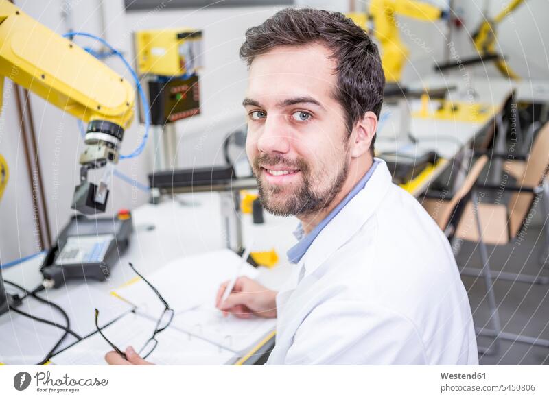 Porträt eines lächelnden Ingenieurs in einer Fabrik, der Notizen macht Fabriken Roboter Ingenieure Technik Techniken Technologie Industrie industriell Gewerbe