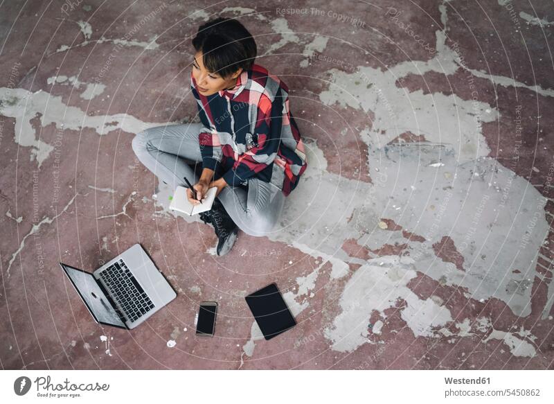 Frau sitzt mit Notebook auf rissigen Boden schreiben aufschreiben notieren schreibend Schrift Laptop Laptops Notebooks Notizbuch Notizbücher Notizbuecher