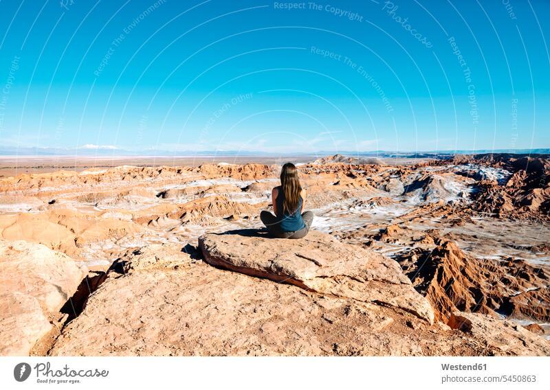 Chile, Atacama-Wüste, Rückenansicht einer Frau, die auf einem Felsen sitzt und die Aussicht betrachtet weiblich Frauen Erwachsener erwachsen Mensch Menschen