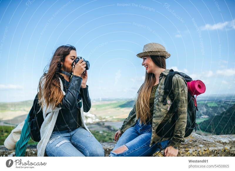 Zwei glückliche junge Frauen auf einer Reise beim Fotografieren Freundinnen Fotoapparat Kamera Fotokamera fotografieren Freunde Freundschaft Kameradschaft