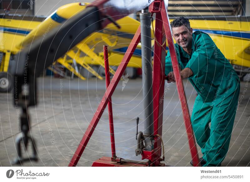Mechaniker im Hangar bei der Reparatur von Leichtflugzeugen Monteur schieben anschieben arbeiten Arbeit reparieren Flugzeug Flieger Flugzeuge Propeller