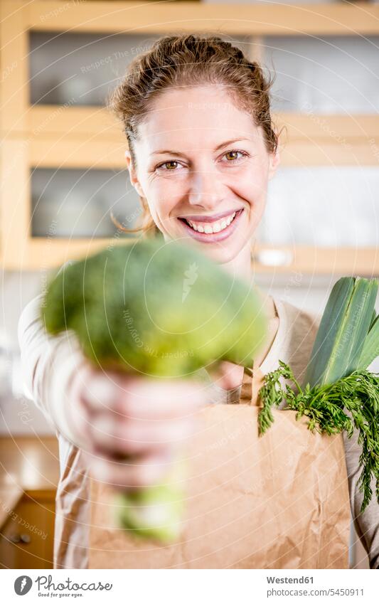Porträt einer glücklichen Frau mit Brokkoli Broccoli Winterblumenkohl Sprossenkohl halten weiblich Frauen Glück glücklich sein glücklichsein Kohl Gemüsekohl