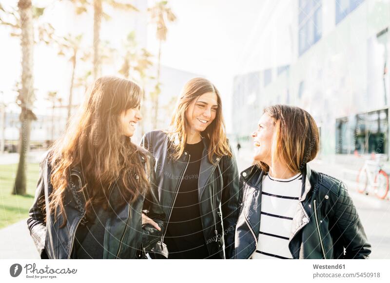 Drei Freunde in schwarzen Lederjacken amüsieren sich Freundinnen Freundschaft Kameradschaft fröhlich Fröhlichkeit Frohsinn Heiterkeit Frau weiblich Frauen