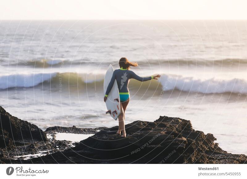 Indonesien, Bali, junge Frau mit Surfbrett gehen gehend geht Surferin Wellenreiterinnen Surferinnen Freizeit Muße tragen transportieren weiblich Frauen