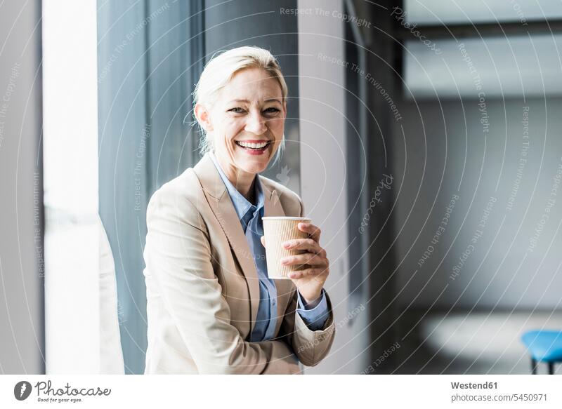 Porträt einer glücklichen Geschäftsfrau mit Kaffee am Fenster Portrait Porträts Portraits lachen Geschäftsfrauen Businesswomen Businessfrauen Businesswoman