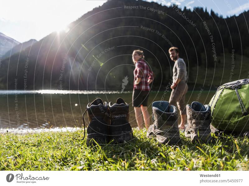 Österreich, Tirol, Wanderschuhe und Paar erfrischend im Bergsee Erfrischung Bergseen Berge Pärchen Paare Partnerschaft wandern Wanderung See Seen Wanderer Schuh