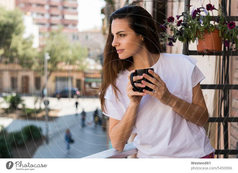Frau mit Kaffeetasse auf Balkon stehend und in die Ferne schauend weiblich Frauen Balkone Erwachsener erwachsen Mensch Menschen Leute People Personen
