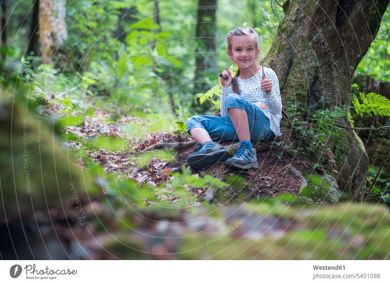 Porträt eines lächelnden kleinen Mädchens im Wald Forst Wälder weiblich Kind Kinder Kids Mensch Menschen Leute People Personen sitzen sitzend sitzt Portrait