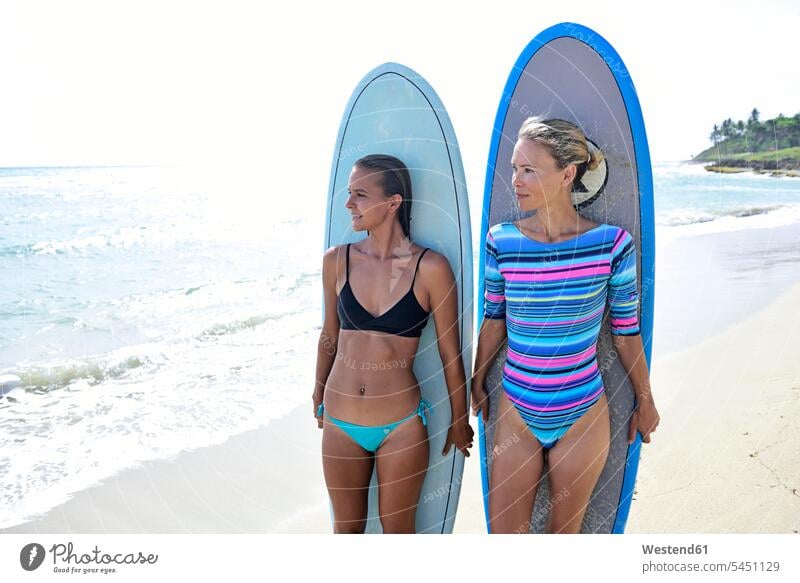 Zwei Frauen am Strand mit Surfbrettern surfboard surfboards Freundinnen stehen stehend steht weiblich Surfen Surfing Wellenreiten Beach Straende Strände Beaches