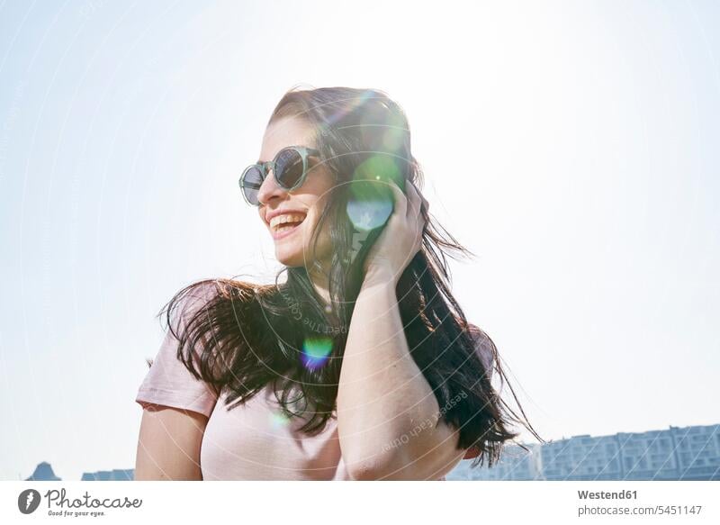Glückliche junge Frau im Freien bei Sonnenschein sonnig lachen weiblich Frauen positiv Emotion Gefühl Empfindung Emotionen Gefühle fühlen Empfindungen emotional