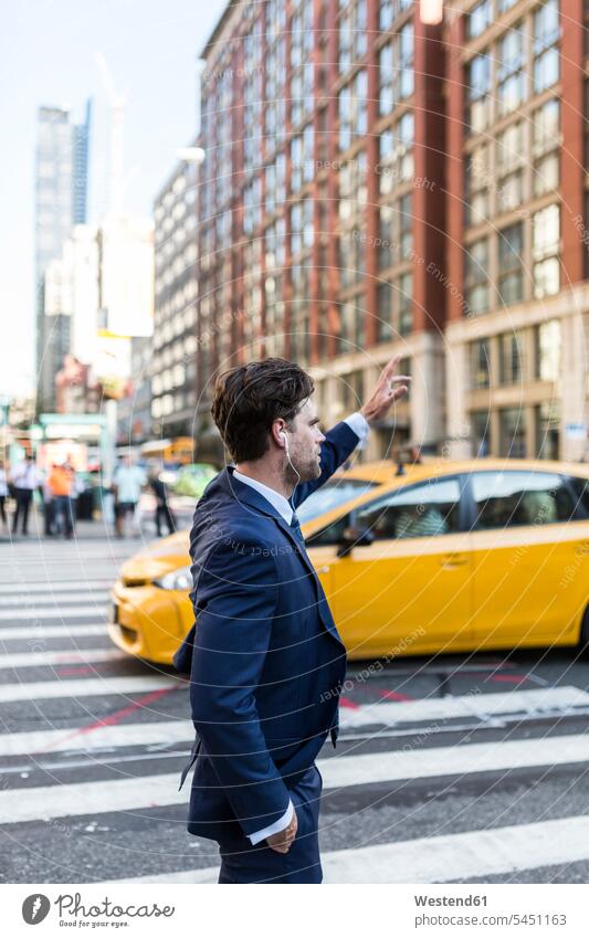 Geschäftsmann in den Straßen von Manhattan, der ein Taxi ruft attraktiv schoen gut aussehend schön Attraktivität gutaussehend hübsch winken Pendler telefonieren