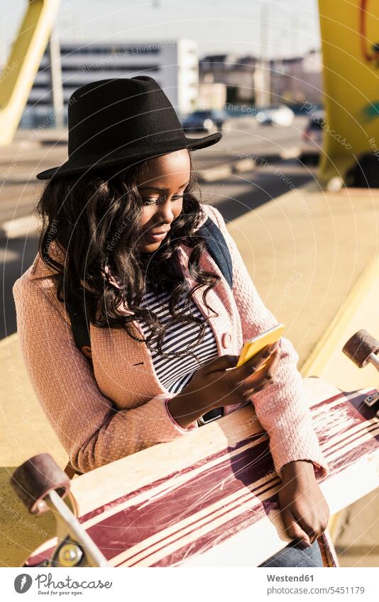 Junge Frau sitzt mit Smartphone auf der Brücke fröhlich Fröhlichkeit Frohsinn Heiterkeit Bruecken Brücken jung weiblich Frauen Freude freuen Verkehrswesen