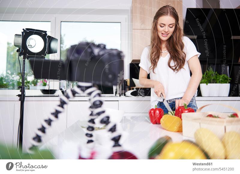 Frau nimmt während des Gemüseschneidens auf Fotokamera Kamera Kameras Küchen Leute Menschen People Person Personen erwachsen Erwachsene Frauen weiblich Essen