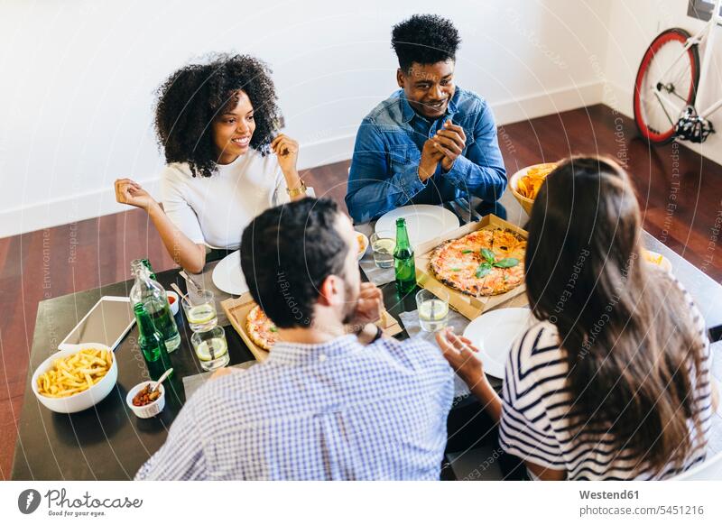 Gruppe von Freunden bei einer Pizza zu Hause Tisch Tische Pizzen essen essend Essen Food Food and Drink Lebensmittel Essen und Trinken Nahrungsmittel