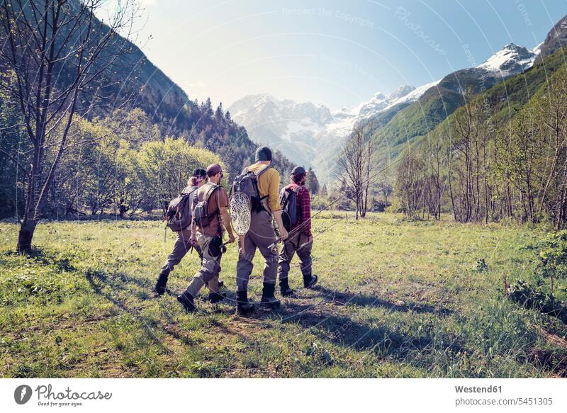 Slowenien, Bovec, vier Angler gehen auf einer Wiese in Richtung Soca-Fluss Wiesen wandern Wanderung gehend geht Mann Männer männlich Freunde Erwachsener