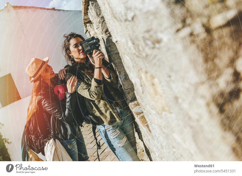 Junge reisende Frauen nehmen mit alter Videokamera auf Freundinnen Videokameras Freunde Freundschaft Kameradschaft Stadt staedtisch städtisch Touristin weiblich