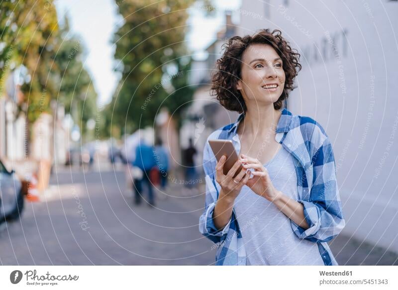 Lächelnde Frau mit Handy in der Stadt lächeln weiblich Frauen Mobiltelefon Handies Handys Mobiltelefone Erwachsener erwachsen Mensch Menschen Leute People