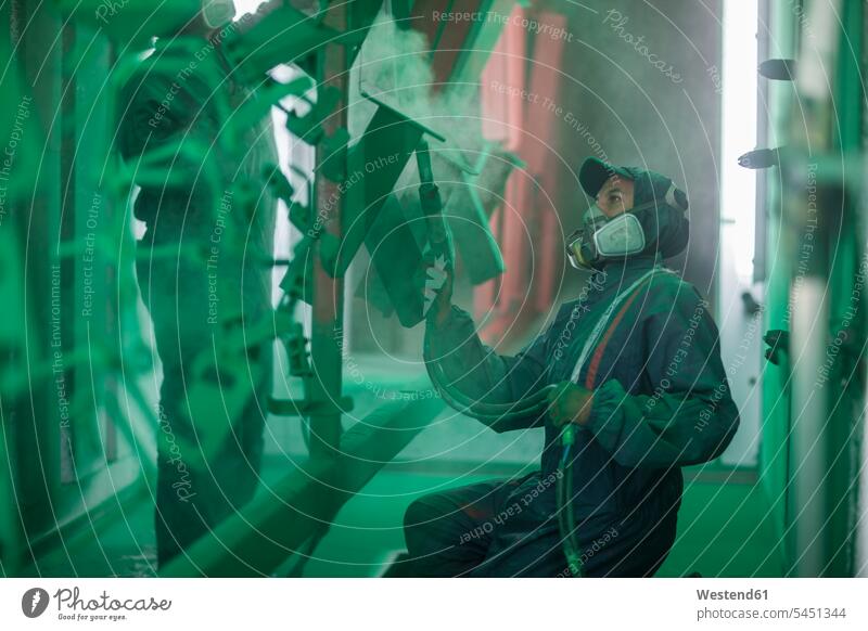 Lackierer beim Spritzen von Stahlteilen in der Spritzkabine einer Fabrik grün Farbe Anstrich Farben Anstriche Arbeiter sprühen spruehen Spritzkammer Farbtöne