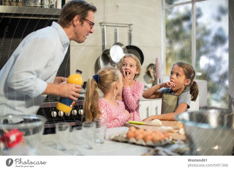 Familie kocht gemeinsam in der Küche Ei Eier Tochter Töchter backen kochen lernen Familien Vater Papas Väter Vati Vatis Papis helfen Fruchtsaft Fruchtsäfte