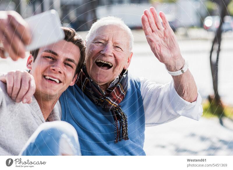 Glücklicher älterer Mann und erwachsener Enkel machen ein Selfie lächeln glücklich glücklich sein glücklichsein Spaß Spass Späße spassig Spässe spaßig Großvater