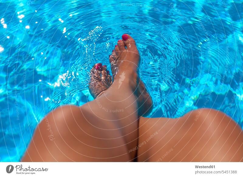 Am Beckenrand sitzende Frau mit Beinen im Wasser Swimmingpool Swimmingpools Schwimmbecken Swimming Pool Swimming Pools weiblich Frauen Urlaub Ferien Mensch